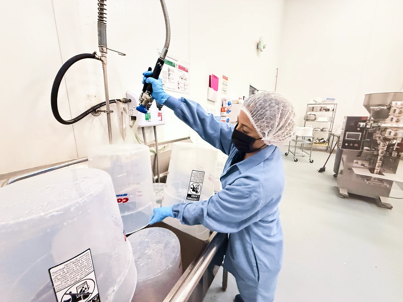 Getty Team sanitation technician cleaning equipment inside a food manufacturing facility.