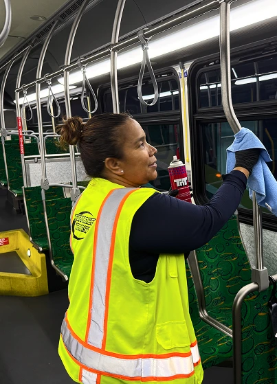 Cleaning professional maintaining the interior of a Torrance Transit bus.